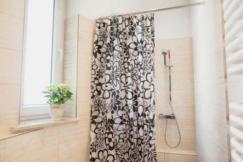 a shower with a black and white shower curtain in a bathroom at pokój na Monciaku in Sopot