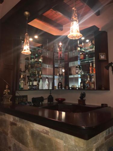 a bar with two lights hanging over a counter at Villa Katerina in Nea Kallikrateia