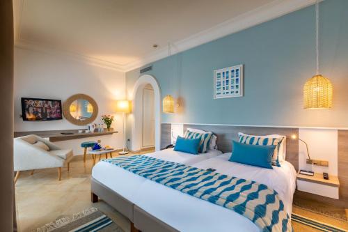 a bedroom with a large bed and a living room at Ulysse Djerba Thalasso & SPA in Houmt Souk
