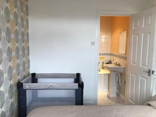 Un dormitorio con una cama y un lavabo y un baño. en Pound Corner, en Godalming