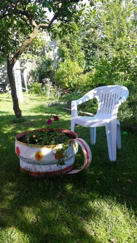 a white bench and a flower pot next to a chair at Guest House on Kostava 23 in K'obulet'i