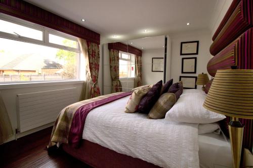 a bedroom with a bed with pillows and a window at The Marlfield in Bellshill