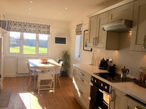 a kitchen with a table and a small kitchen with a table and a dining room at The Cornish Retreat in Bude