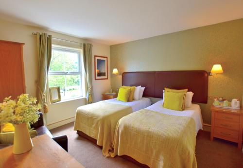 a hotel room with two beds and a window at Bryn Tyrch Rooms in Capel Curig