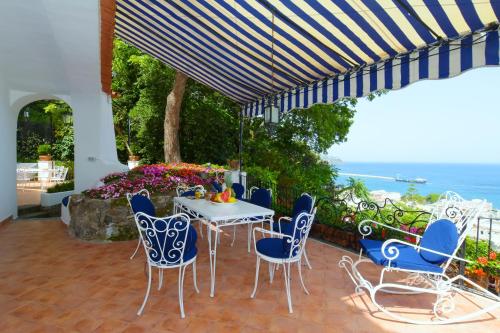 a patio with a table and chairs and the ocean at Aglaia Luxury Seaview Villa in Ischia