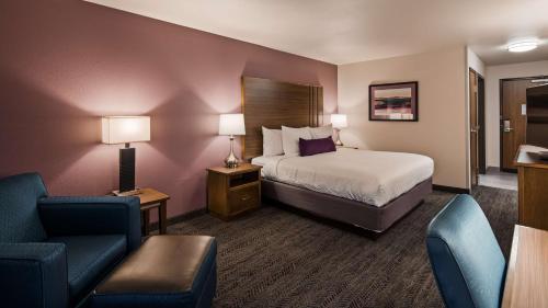 ラピッドシティにあるBest Western Plus Rapid City Rushmoreのベッドと椅子付きのホテルルーム