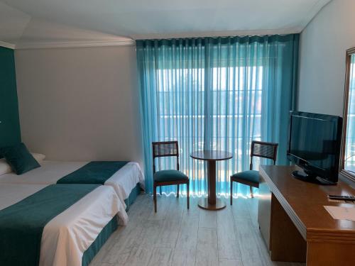 a hotel room with a bed and a table and chairs at Nueva Colina in Tomiño