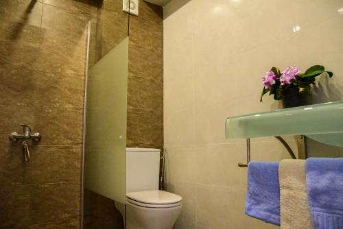 a bathroom with a toilet and a shower with purple towels at Complex Sportiv Break in Mamaia