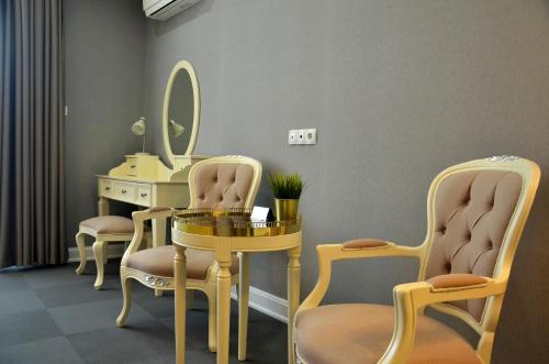 a salon with a table and chairs and a mirror at Hotel Konak in Momchilgrad