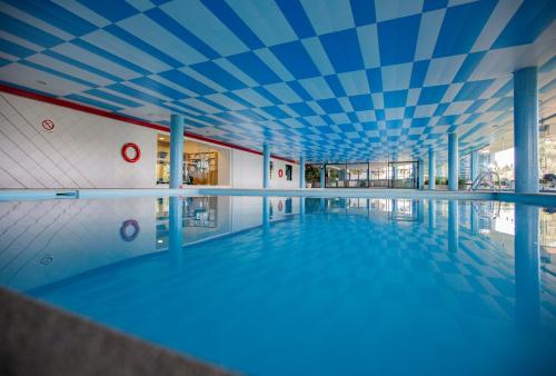 an empty swimming pool with a blue ceiling at Hotel Miracorgo in Vila Real
