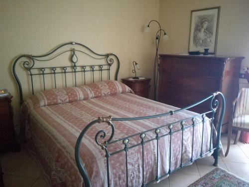 a bedroom with a metal bed and a dresser at Ai piedi del Vulcano in Gravina di Catania