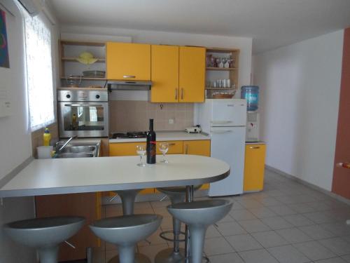 une cuisine avec des armoires jaunes et une table avec deux verres à vin dans l'établissement Zaton - Nin Family apartment, à Zaton