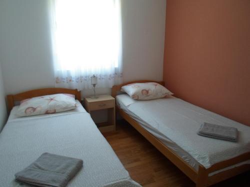 - 2 lits dans une petite chambre avec fenêtre dans l'établissement Zaton - Nin Family apartment, à Zaton