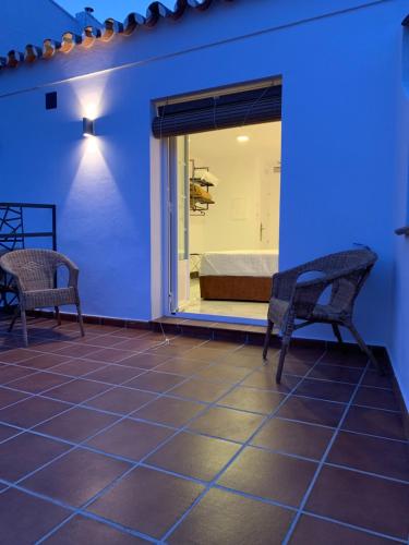 a room with two chairs and a window with a bed at Hotel Don Miguel in Ronda