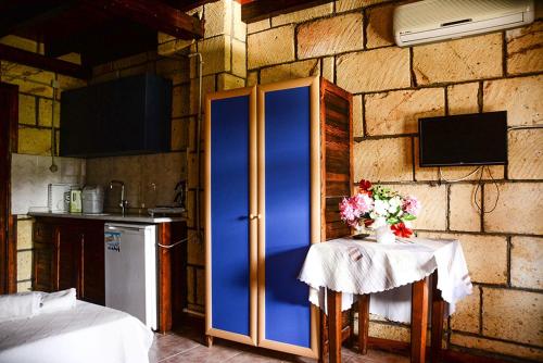 a kitchen with a blue refrigerator and a table with flowers at Borabora Apart Hotel in Bitez