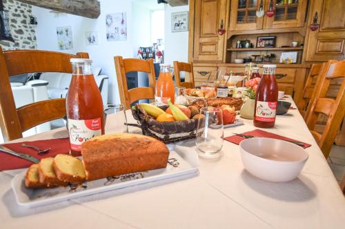 ein Tisch mit einem Teller Brot und einer Schale Obst in der Unterkunft La Brocherie in Magny-le-Désert