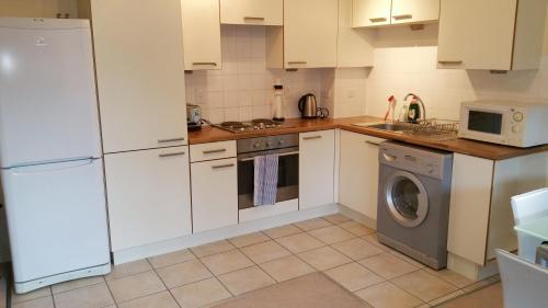 a kitchen with a refrigerator and a washing machine at Oxford Apartment-- Free parking 2 Bedrooms-2Bathrooms-Located in Jericho Oxford close to Bus and Rail station in Oxford