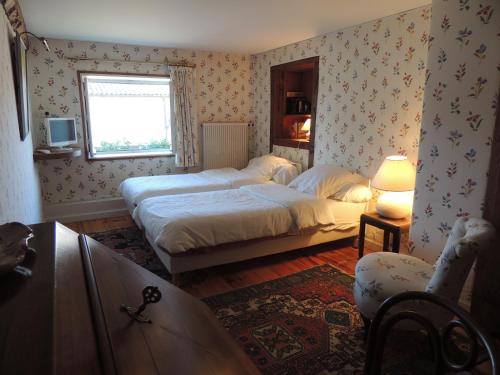 une chambre avec deux lits et une fenêtre dans l'établissement Chez Jacotte et Elia, à Saint-Galmier