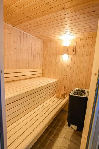- un petit sauna en bois avec un banc dans l'établissement La Brocherie, à Magny-le-Désert
