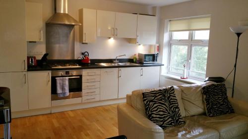 uma sala de estar com um sofá e uma cozinha em Oxford Apartment- Free parking 2 Bedrooms-2Bathrooms-Located in Jericho Oxford close to Bus and Rail sation em Oxford