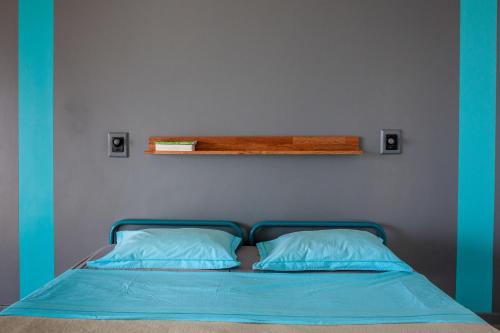 a bed with two pillows and a shelf above it at Auberge Jeunesse Nouméa in Noumea