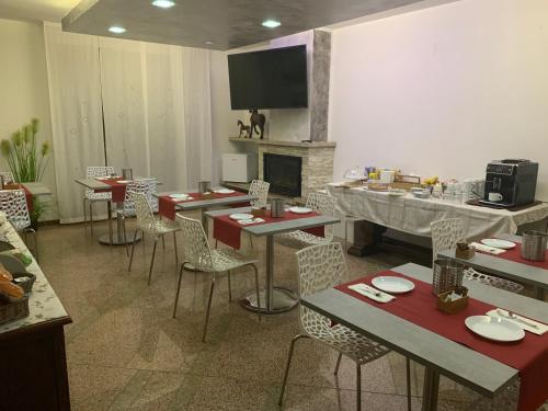 a dining room with tables and chairs and a fireplace at Villa Cuore in Tavernerio