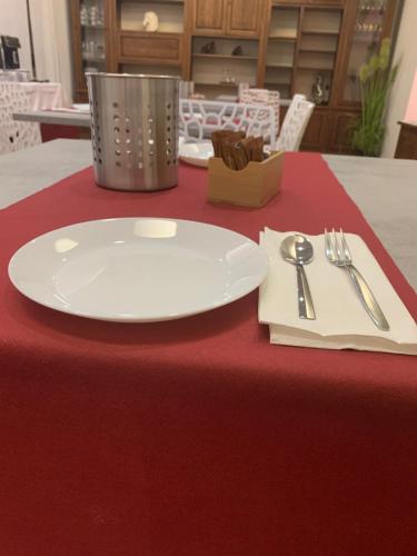 a white plate sitting on top of a red table at Villa Cuore in Tavernerio