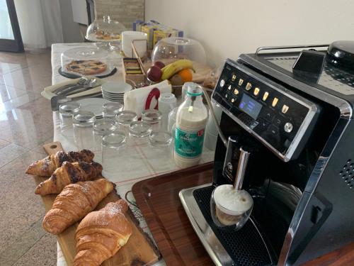 a table with bread and croissants and a coffee maker at Villa Cuore in Tavernerio