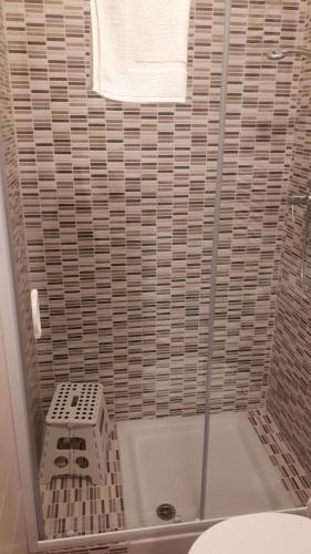 a bathroom with a shower with a toilet and a towel at Le camere di Sabrina con bagno in camera in Sarzana