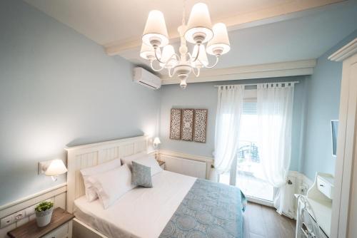 - une chambre avec un lit et un lustre dans l'établissement Siel Seaside Boutique Homes, à Peraia