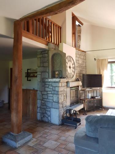 a living room with a stone fireplace and a tv at La parenthèse in Chimay