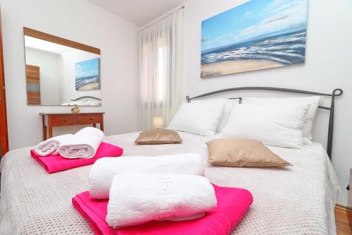 a bedroom with a bed with pink and white towels at Vila Mila in Vela Luka