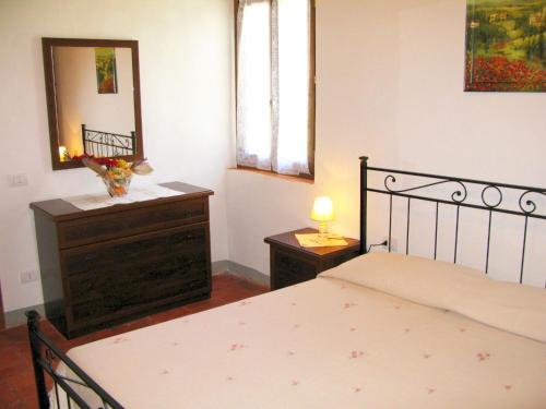 une chambre avec un lit, une commode et un miroir dans l'établissement Agriturismo Martignana Alta, à Empoli