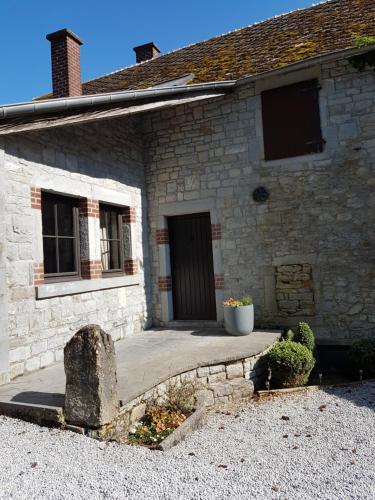 a stone house with a walkway leading to a door at La parenthèse in Chimay