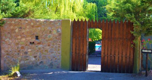 a wooden gate leading to a stone wall at Cabaña Suiza in Cacheuta