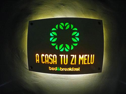 a sign on a wall with a clock on it at A casa tu zi Melu in Felline