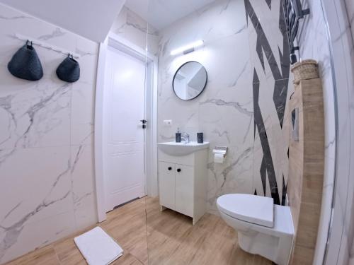 a bathroom with a toilet and a sink and a mirror at Baltic Pearl in Ustka