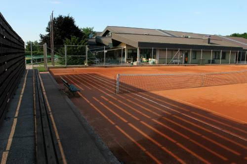 a tennis court with a bench in front of a building at Tennis- und Freizeitzentrum Neudörfl in Neudörfl