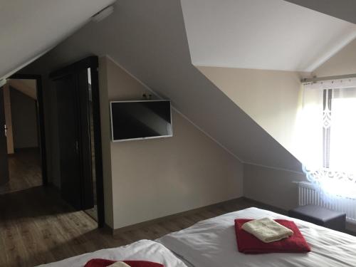 a bedroom with a bed with a tv on the wall at Pieninski Mak. in Szczawnica