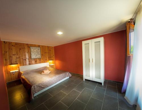 ein Schlafzimmer mit roten Wänden und einem Bett darin in der Unterkunft Alexander in Shkorpilovtsi