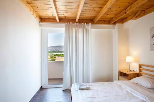 una camera con un letto e una grande finestra di Arion Stables & Apartments a Hersonissos