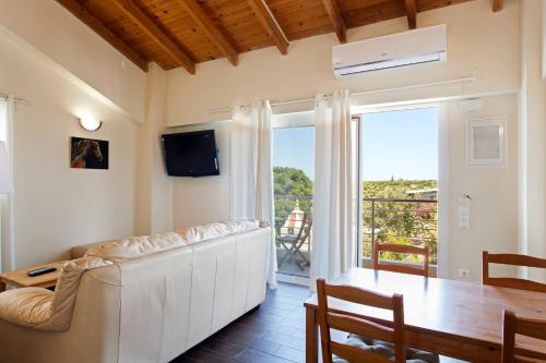 un soggiorno con divano bianco e tavolo di Arion Stables & Apartments a Hersonissos