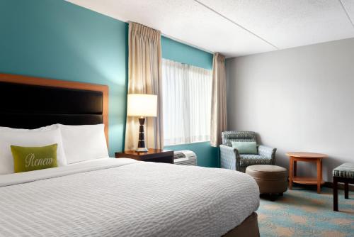 a hotel room with a bed and a chair at The Inn at Saint Mary's in South Bend