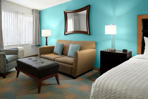 a hotel room with a bed and a couch and a chair at The Inn at Saint Mary's in South Bend
