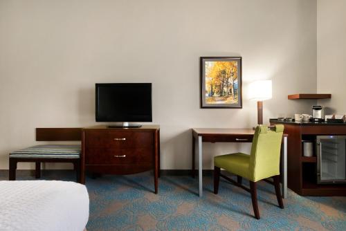 a hotel room with a bed and a desk and a television at The Inn at Saint Mary's in South Bend