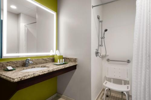 a bathroom with a sink and a shower with a mirror at The Inn at Saint Mary's in South Bend