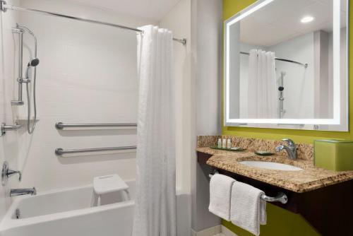 a bathroom with a tub and a sink and a mirror at The Inn at Saint Mary's in South Bend