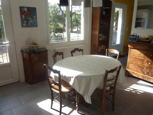 une cuisine avec une table et un chiffon de table blanc dans l'établissement Chambre d'Hôtes La Dune - face mer, à Saint-Michel-Chef-Chef