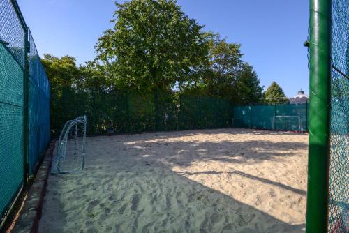 a tennis court with a fence and a tennis court at Holiday Resorts in Balatonszárszó