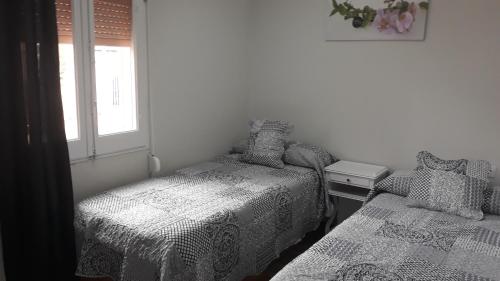 sypialnia z 2 łóżkami i oknem w obiekcie loft turistic w mieście San Vicente dels Horts